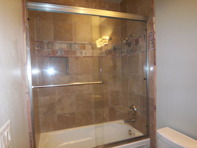 Tub slider in brushed nickel metal with through-the-glass towel bar and knobs