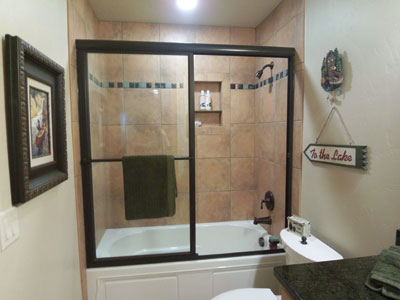 Tub slider in oil-rubbed bronze metal with towel bar attached to the metal European header